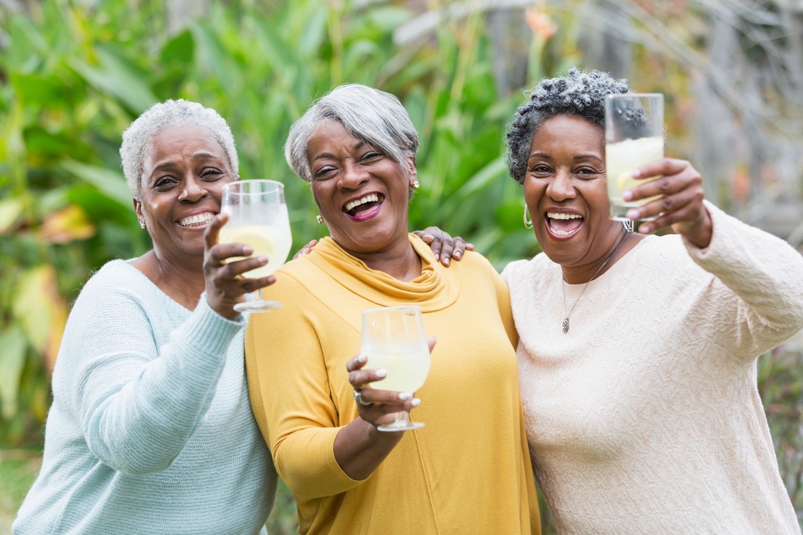 Three senior African American woman toasting